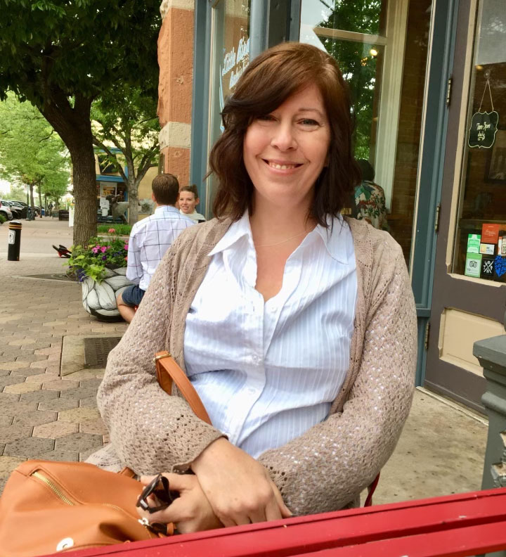 The artist's photo sitting outside a cafe.