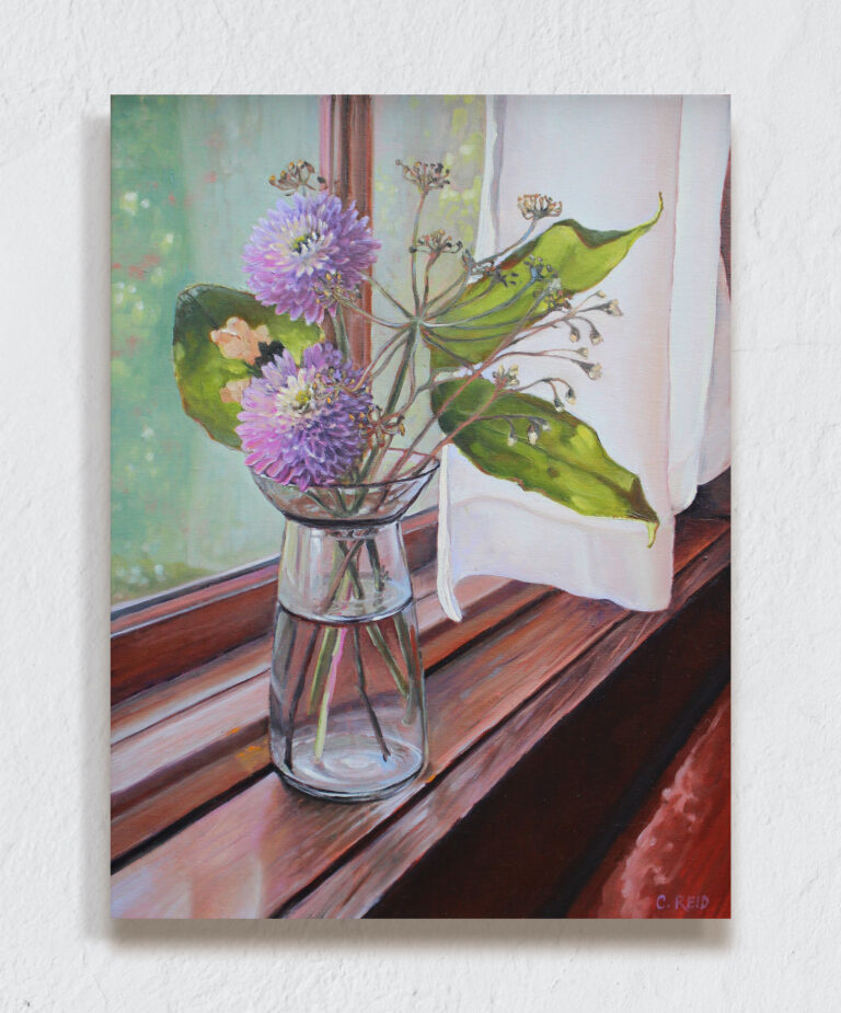 Dahlia's in a vase next to a window.